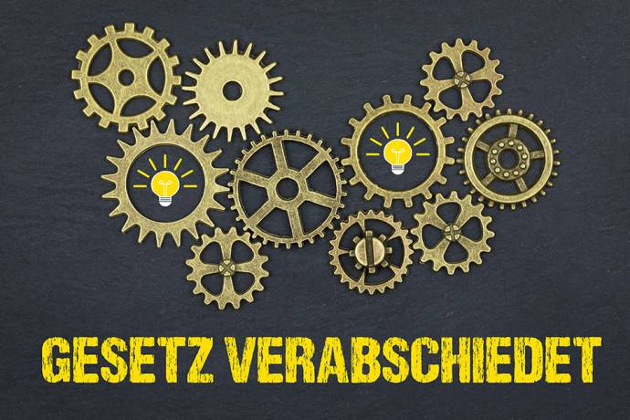 Foto: Zahnräder über Schriftzug GESETZ VERABSCHIEDET